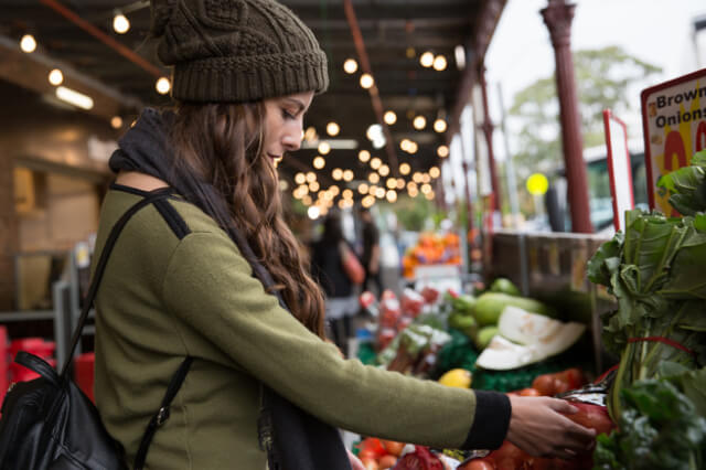 woman looking at fresh produce at an outdoor market