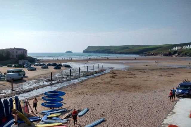 A view of Polzeath Beach with Pentire Point in the background.