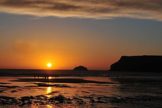 The sun goes down over Polzeath Beach in Cornwall.