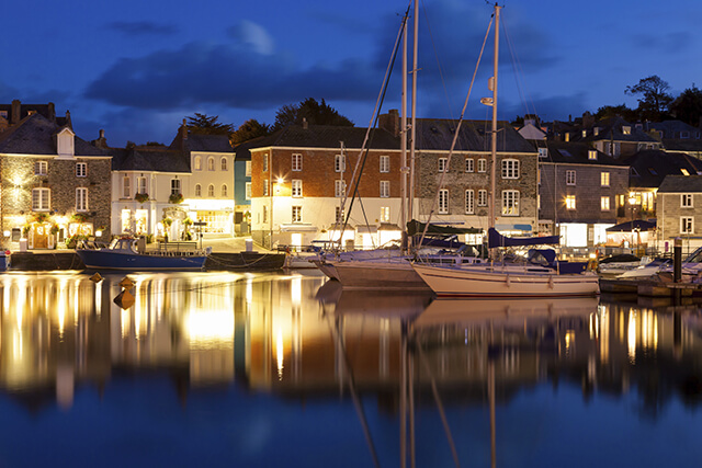 Padstow TIC - a view of Padstow harbour with boats at night.