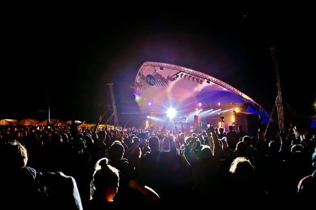 A DJ set taking place on a stage with a crowd.